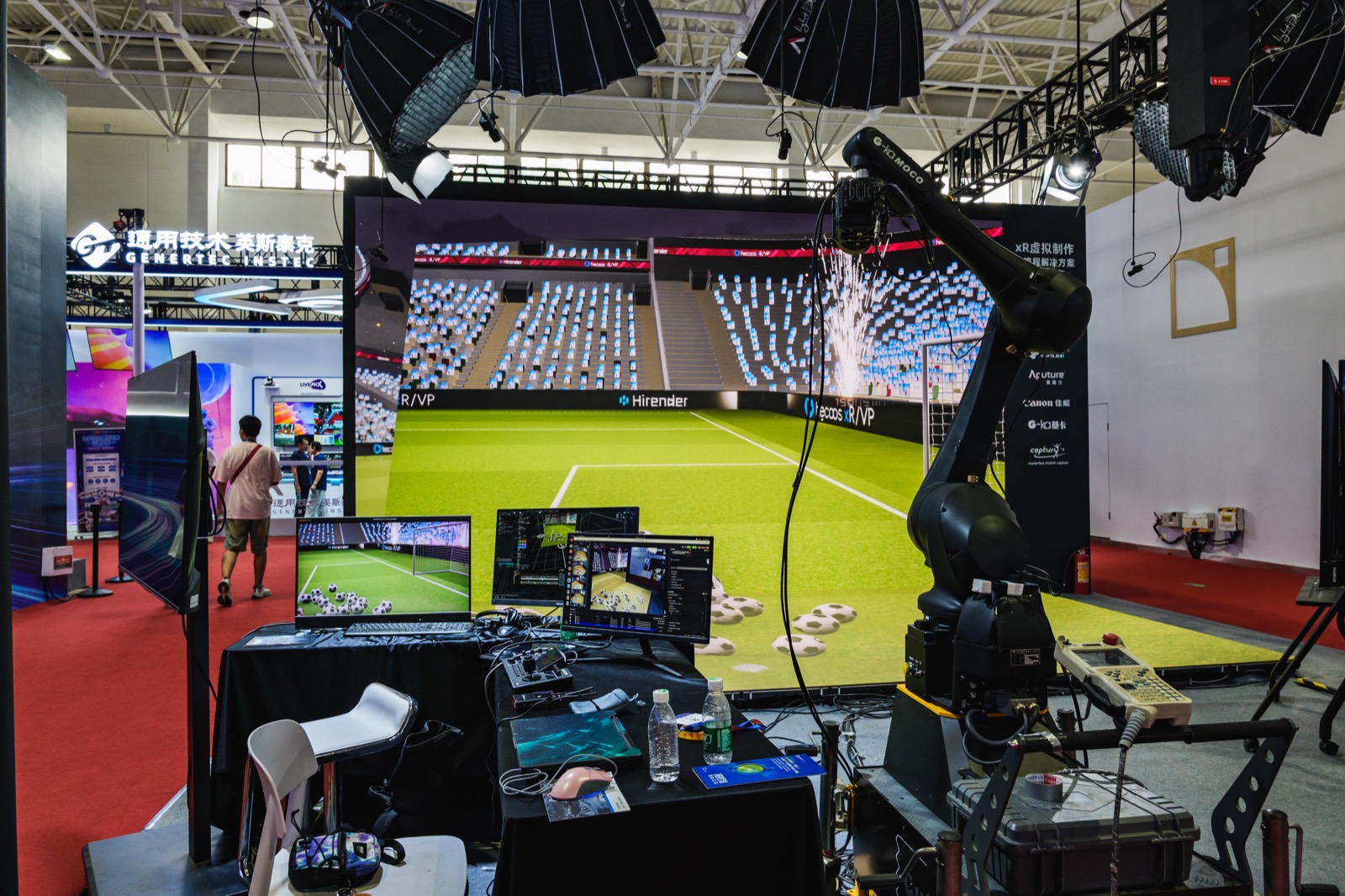 An XR virtual production stage with a game-engine stadium scene rendered live onto a large LED wall and a motion-control camera